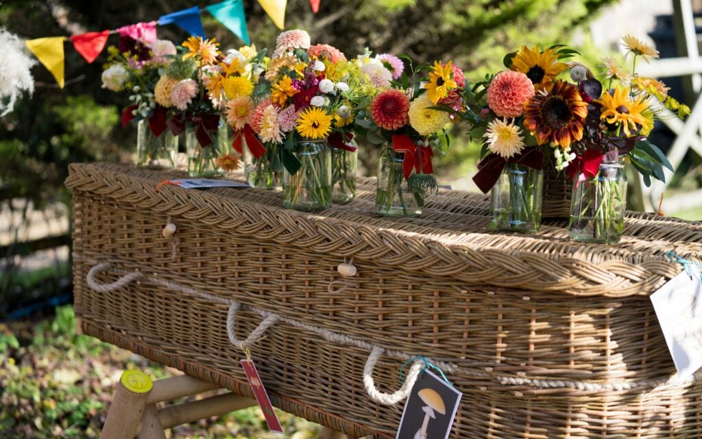 Wicker coffin covered with flowers
