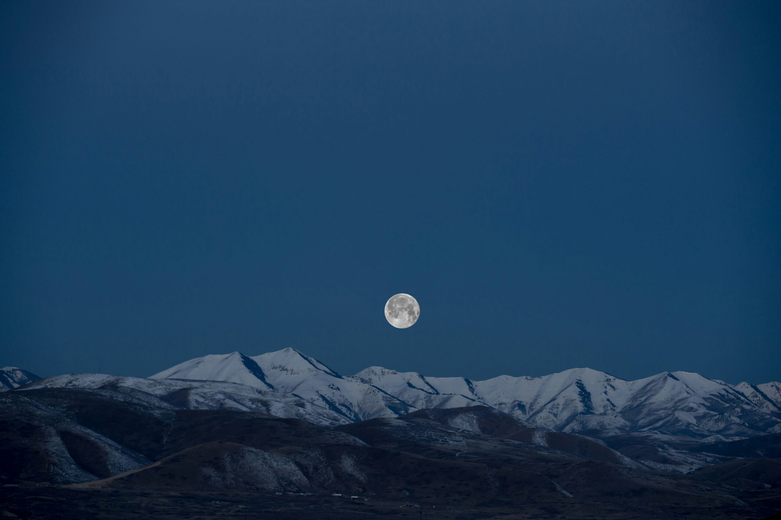 Full moon over snowy mountains