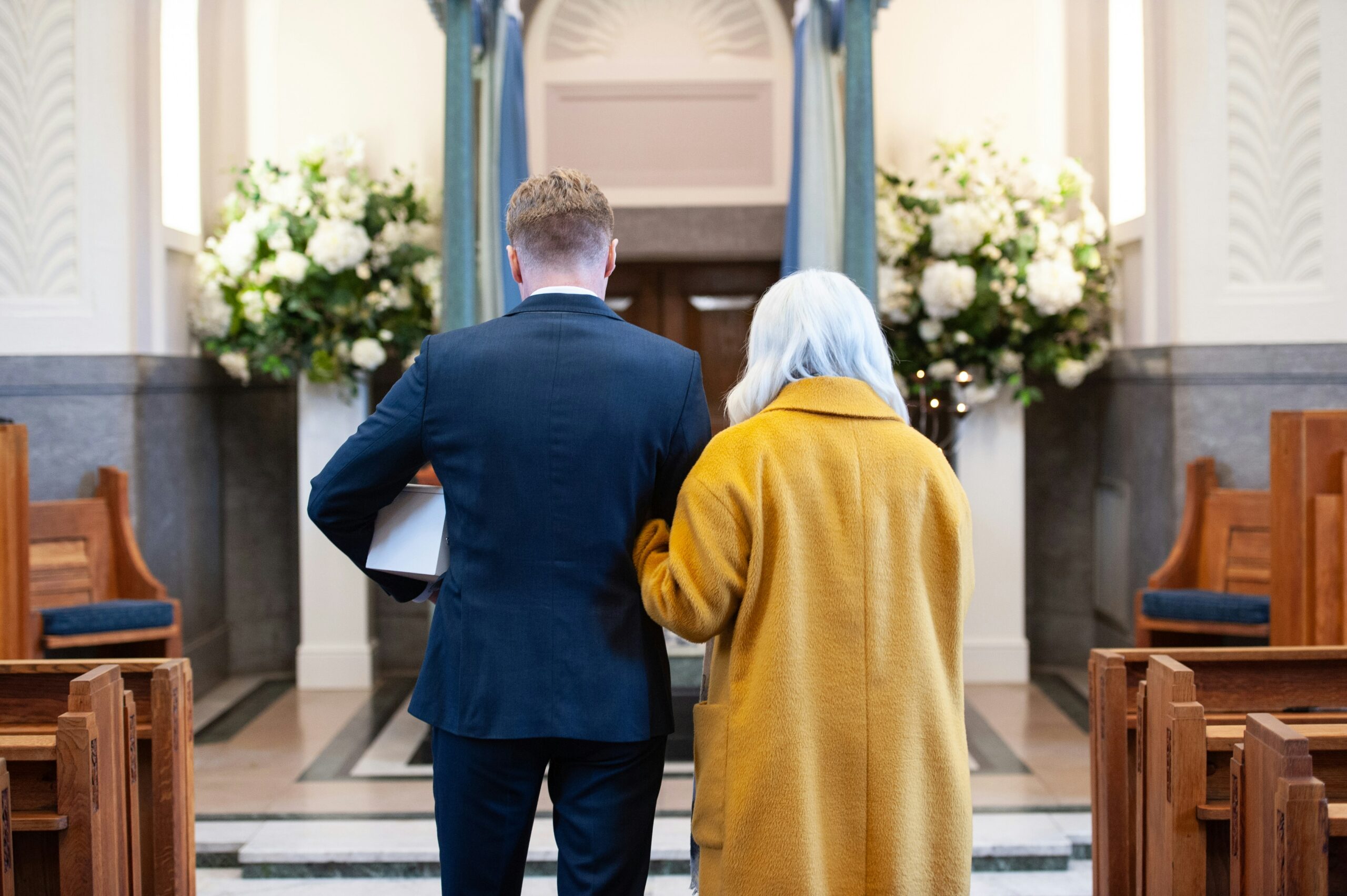 Mother and son walking down the aisle at a funeral