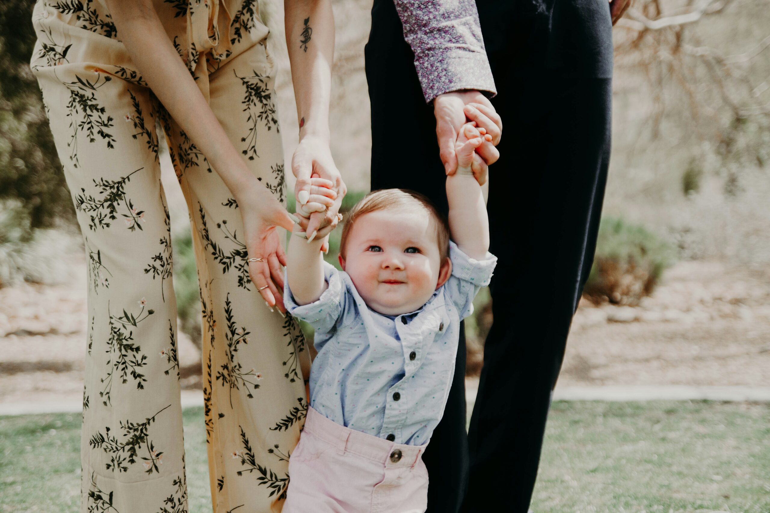 Baby being walked by parents