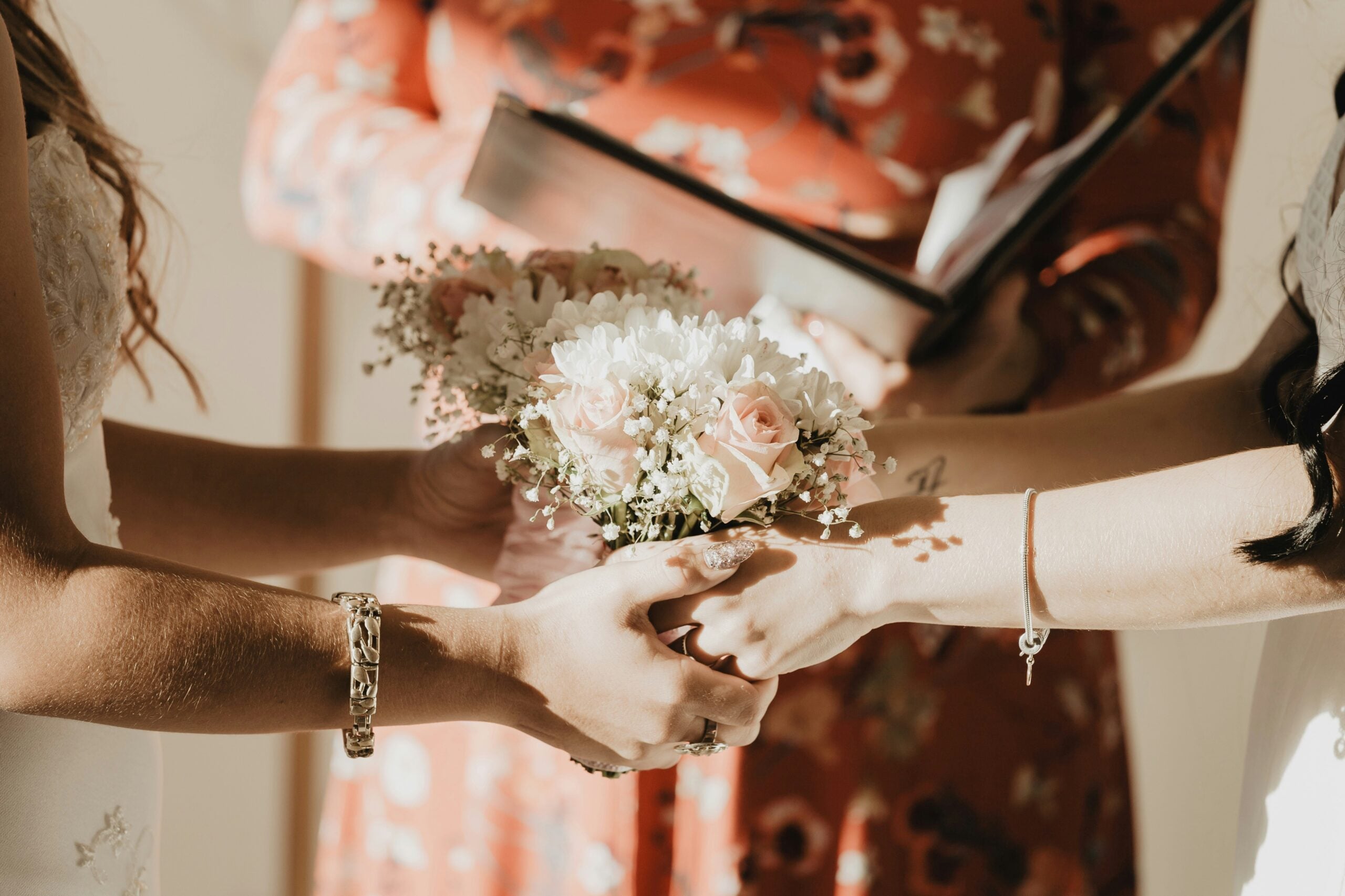 Women holding hands at a wedding