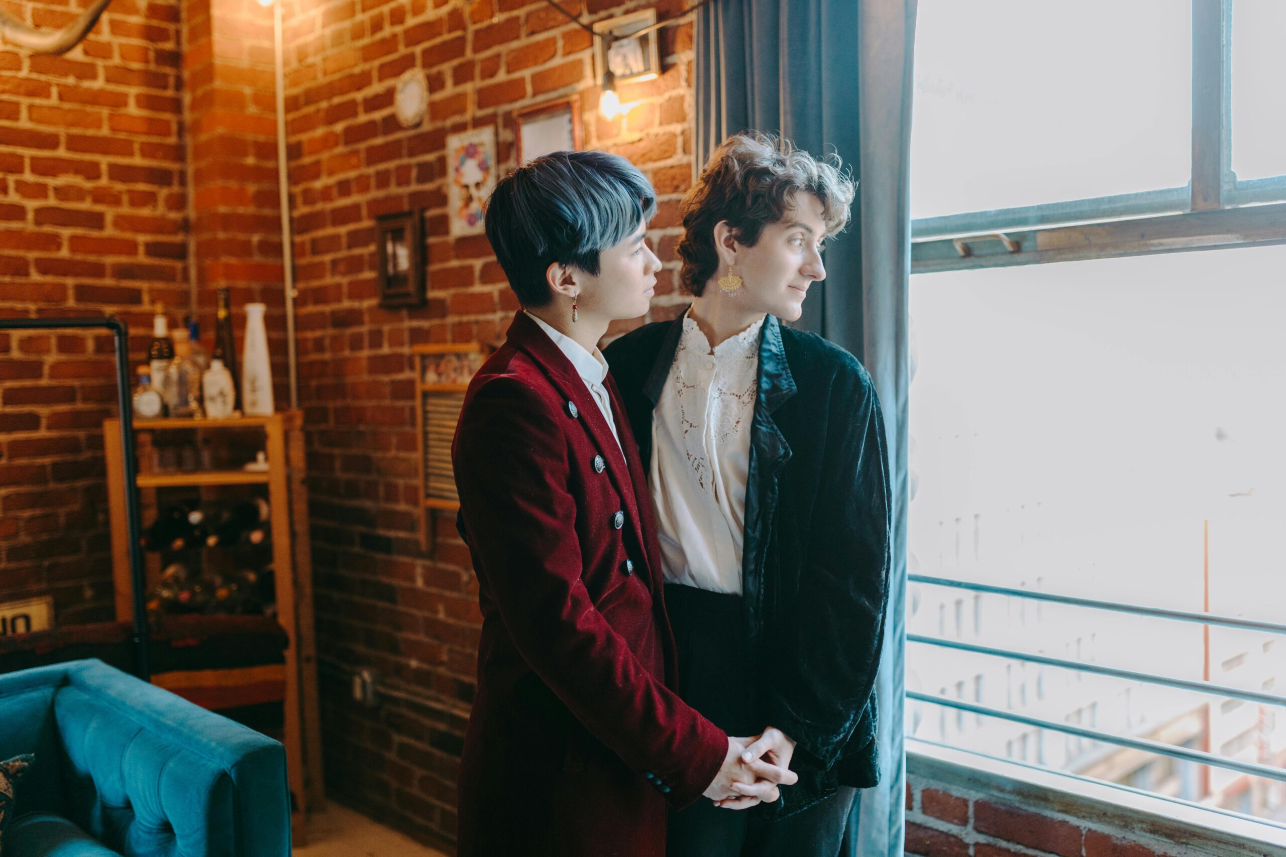 Queer couples standing by a window