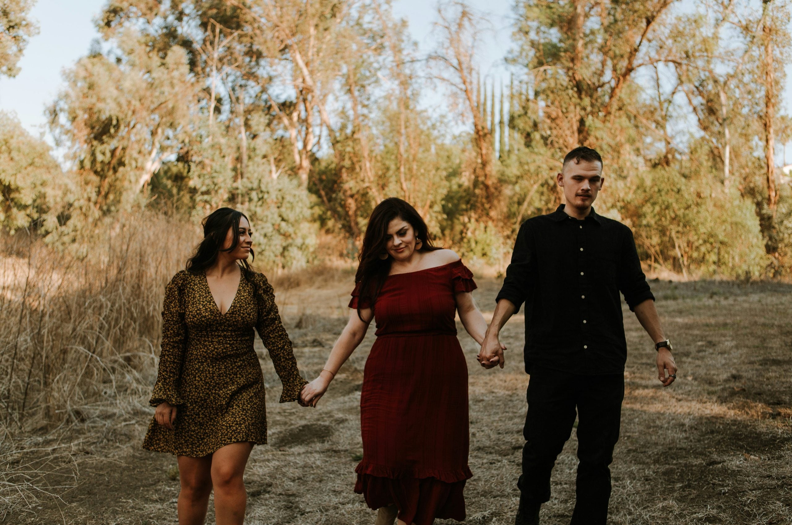 Throuple holding hands